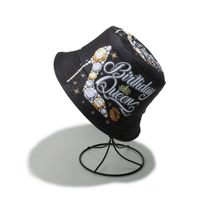 Detail of black cotton bucket hat featuring white Birthday Queen text and crown design