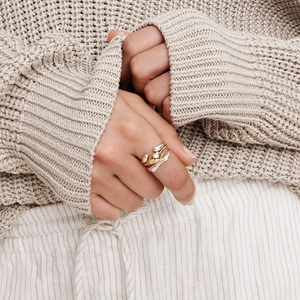 Close-up of a multi-layer gold and silver twisted ring on a model's hand