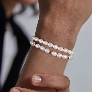 Elegant double-layer freshwater pearl bracelet with gold bead accents on a woman's wrist