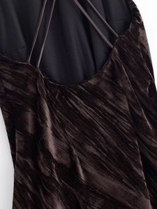 Close-up of velvet sleeveless dress featuring a textured fabric and slim cross straps