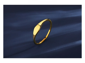 Detailed view of a gold minimalist ring with a mirror-finish on a textured background