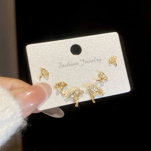 Détail de boucles d'oreilles feuilles de ginkgo dorées avec perles et cristaux