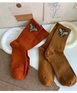 Detail of knitted cotton mid-tube socks with 3D bee embroidery in caramel and coffee