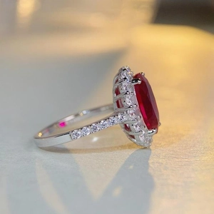 S925 sterling silver ring featuring a large oval red ruby center stone with halo accents
