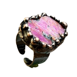 Vintage copper ring with irregular raw pink stone in a rustic prong setting on white background