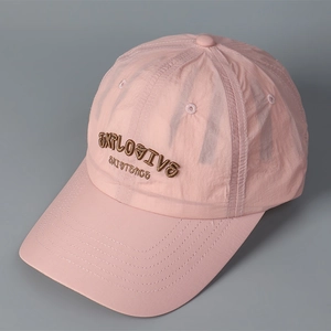 Detailed view of pink quick-dry baseball cap featuring brown 3D letter embroidery