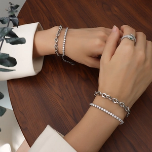Bracelet double chaîne argentée avec bague serpent sur fond en bois de noyer foncé