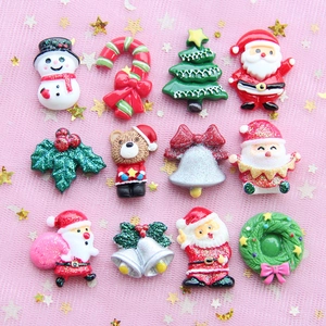 Assorted glittery Christmas resin charms featuring Santa, snowmen, and trees on pink tulle