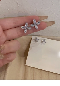 Macro detail of silver flower earrings with four marquise-cut marquise zircons