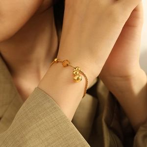 Golden titanium steel bracelet with Fu character charm and gourd pendant on wrist