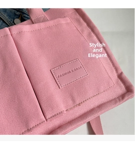 Dettaglio della borsa tote in tela rosa con etichetta fashion, cuciture e tasca esterna