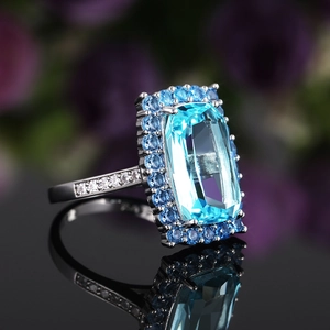 Macro d'un zircon bleu rectangulaire avec sertissage halo sur une bague en argent