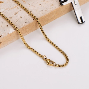 Golden box chain necklace for women with lobster clasp on natural stone background