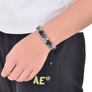 Close-up of green aventurine and black magnetic bead adjustable woven bracelet on wrist