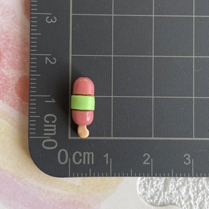 Vue macro d'une breloque glace en résine de 1,5cm avec détails rose et vert pastel