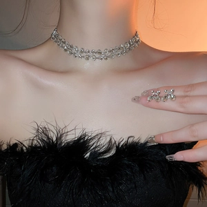 Detail of silver double-strand rhinestone necklace and cross earrings on a model