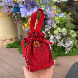 Red jacquard wedding candy bag with gold Xi pendant and ribbon drawstring closure