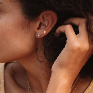 925 silver star and gold triangle stud earrings with crystals worn by a model