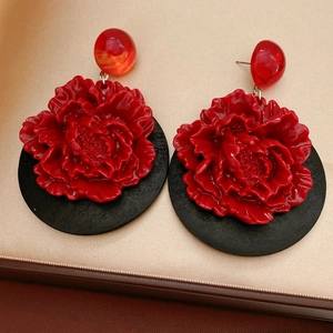 Vue détaillée de boucles d'oreilles fleur rouge sur satin doré avec base noire