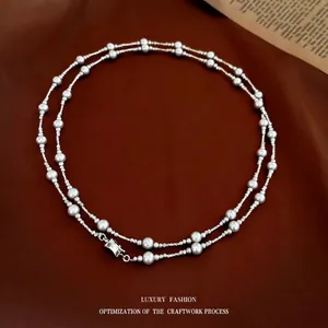French style pearl and textured silver bead necklace on brown leather background
