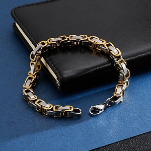 Detail of two-tone gold and silver stainless steel square link chain bracelet with clasp