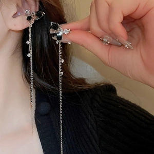 Detail of butterfly and black rose tassels with shimmering cubic zirconia on earring