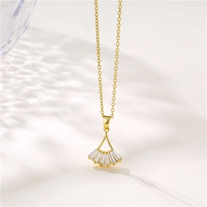 Golden ginkgo leaf necklace with zircon stones on white background with soft light