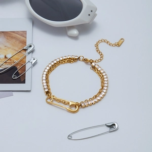 Close-up of gold safety pin bracelet with dual cubic zirconia chains and lobster clasp