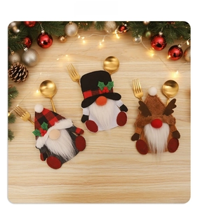 Detailed view of Christmas gnome and reindeer cutlery holders on a festive wooden tabletop
