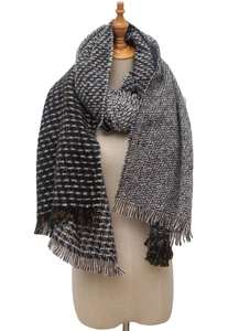 Close-up of thick knitted scarf featuring houndstooth pattern and fringe trim details