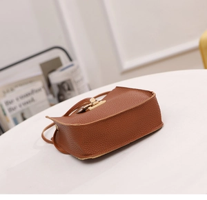 Vue détaillée du sac bandoulière en cuir grainé marron avec couture latérale et fermoir doré