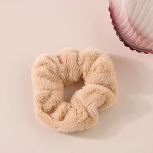 Dettaglio dell'elastico per capelli in peluche beige con morbida finta pelliccia e elastico