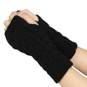 Detail of black cable knit fingerless gloves showing arm warmer texture and pattern