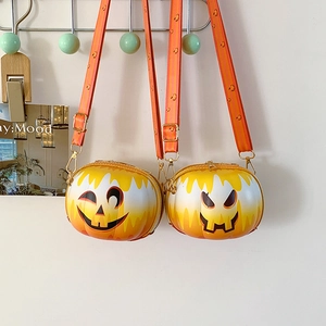 Detail of pumpkin-shaped cross-body bags with smiley face design and striped straps