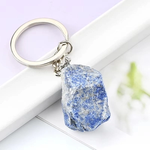 Natural lapis lazuli raw stone keychain with silver metal ring on bright background