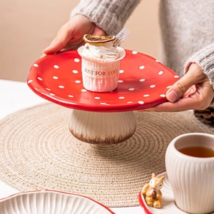 Ceramic red mushroom cake stand with white polka dots and textured base for desserts