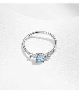 Detailed top view of s925 silver ring featuring a round blue gemstone and baguette diamonds