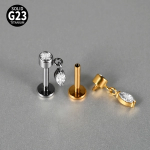 Macro view of solid G23 titanium labret studs with sword charms and zircon stones