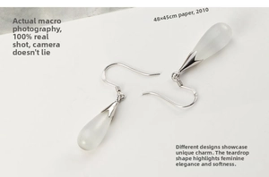Detailed close-up of silver drop earrings with translucent white moonstone pendants