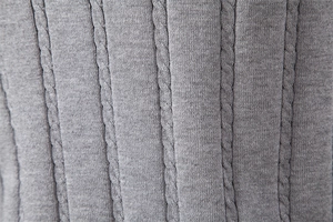 Detailansicht der grauen Strickstruktur mit Zopfmuster und vertikalen Rippenmustern