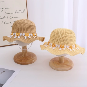 Detail of children's straw hats with white lace ribbon and daisy flower decorations