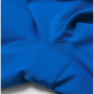 Détail macro des coutures plates renforcées sur un pantalon de yoga bleu roi
