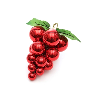 Detail of red grape-shaped Christmas ball ornaments with glossy finish and green leaf
