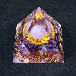 Macro detail of amethyst Orgonite pyramid with gold foil and floating lotus crystal ball