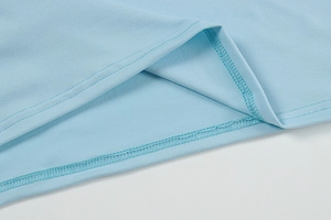 Dettaglio ravvicinato dell'orlo in maglia azzurra con cuciture a doppio ago professionali