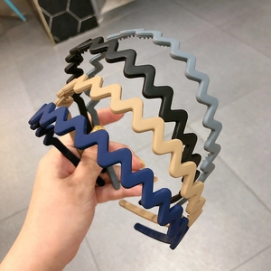 Set of four wavy matte plastic headbands in blue, beige, black, and grey colors