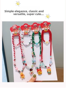 Detailed view of children's Christmas beaded necklaces and bracelets with holiday pendants