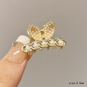 Detail view of 2.5cm gold butterfly hair claw with white pearls and luxury finish