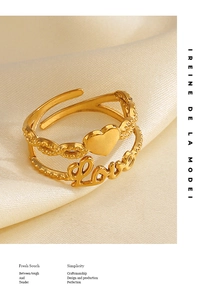 Detail of gold double-layer adjustable ring with heart and Love motifs on silk