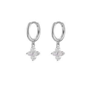 Close-up of silver hoop earrings with shimmering crystal-paved four-leaf clover petals